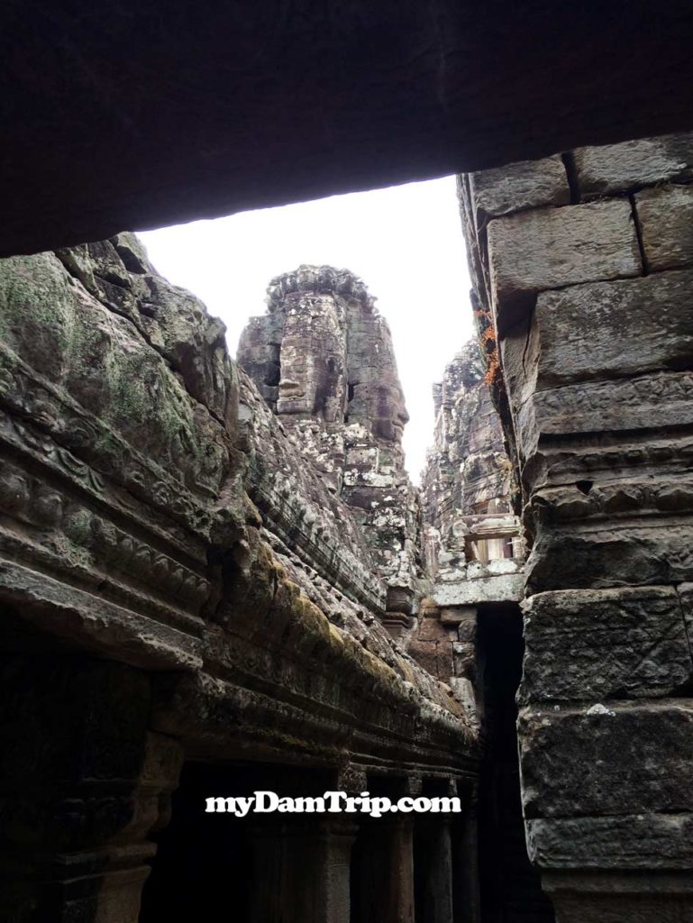 Peeking Through Narrow Corridor Showing Faces In Tower Angkor Thom